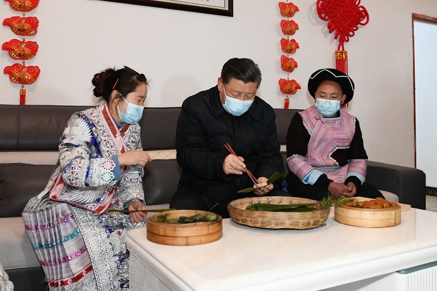2021年2月3日下午，習近平在貴州畢節(jié)市黔西縣新仁苗族鄉(xiāng)化屋村苗族村民趙玉學家，同一家人邊聊家常邊制作當?shù)貍鹘y(tǒng)節(jié)日食品黃粑。新華社記者 李學仁 攝